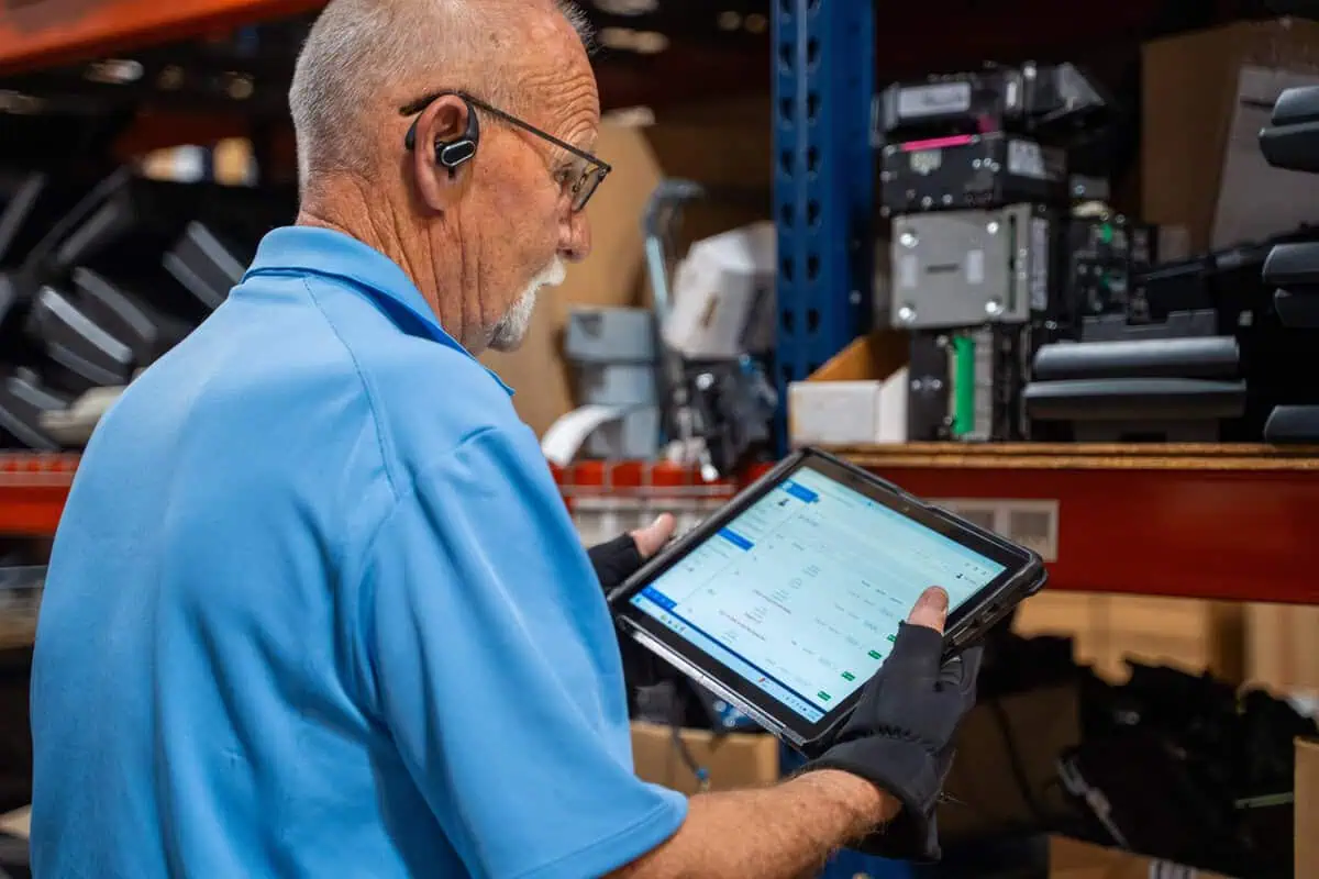 Technician checks tablet for store level system maintenance, focusing on site speed and uptime consistency.