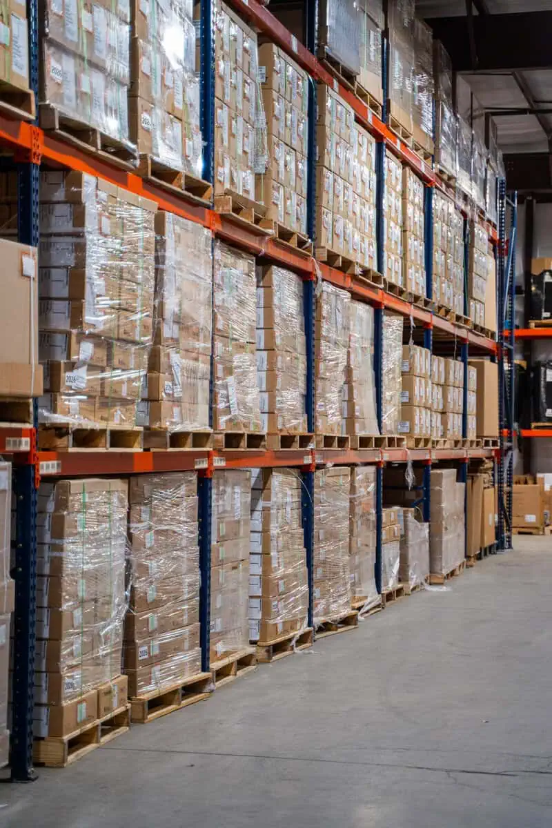 Warehouse shelves stacked with boxes for efficient warranty management and asset enterprises operations.