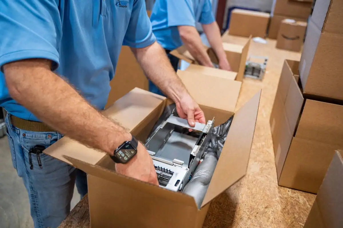Technician packing tech equipment, exemplifying Asset Enterprises' end support across tech lifecycles.