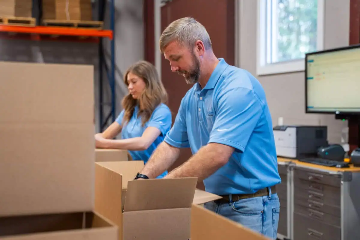 Technicians in blue shirts packing boxes, highlighting site maintenance speed and consistency at store level.