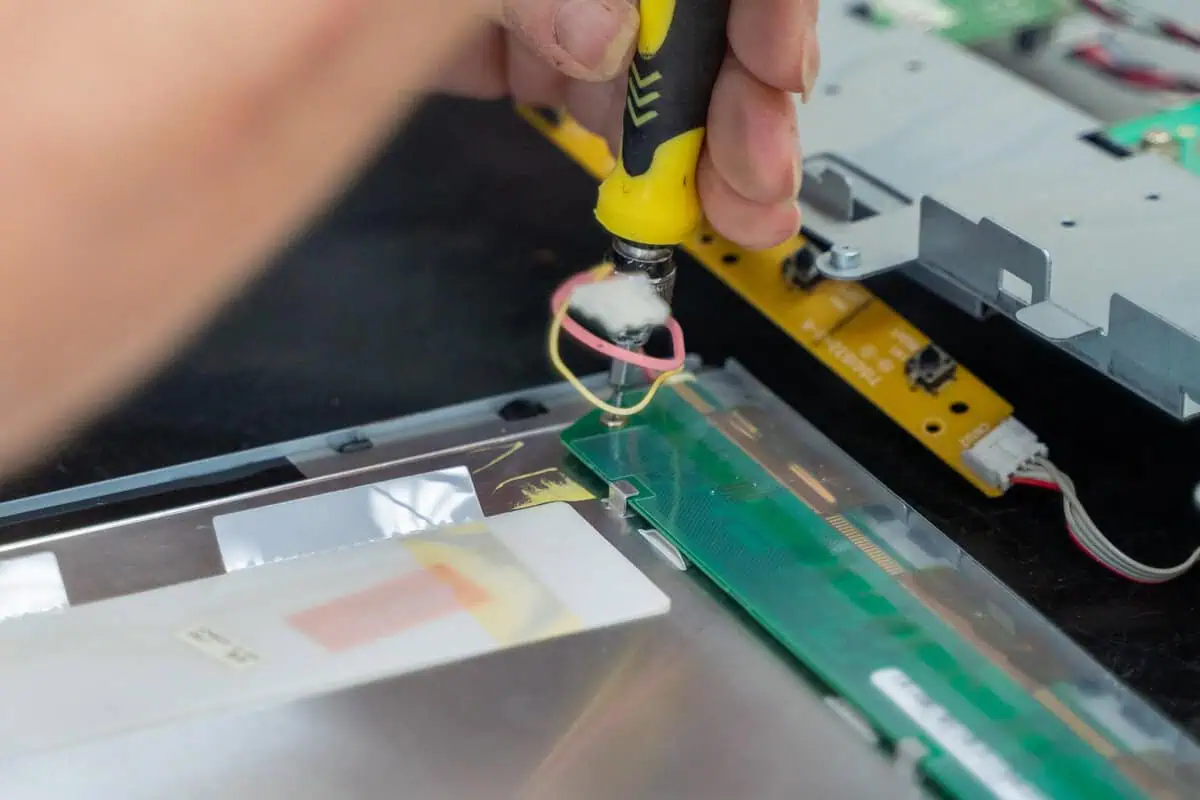 Soldering a circuit board, highlighting the precision crucial in amp parts logistics and warehousing.