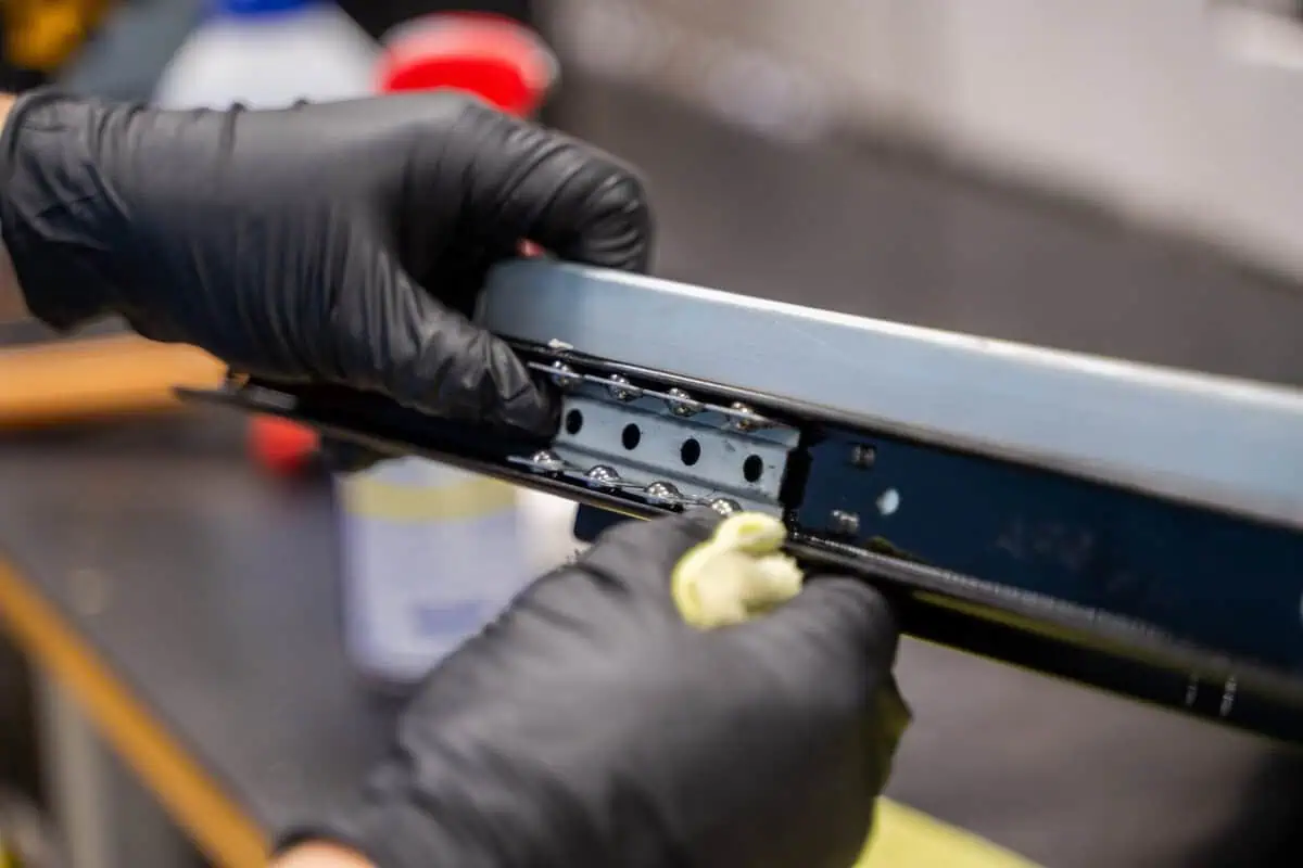 Gloved hands carefully de-installing a component, highlighting how discipline matters most in preventing costly mistakes for Asset Enterprises.