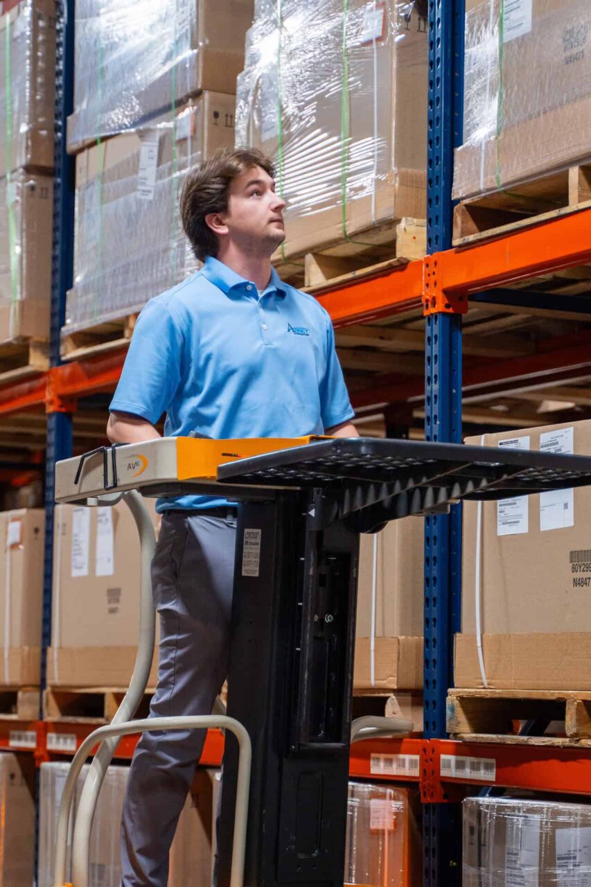 Warehouse worker organizing boxes on shelves, highlighting our trusted hardware partners and strong partnerships.